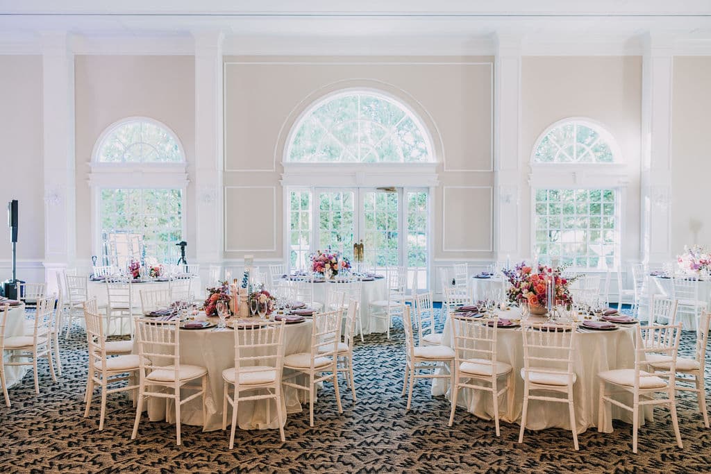 Ballroom ceremony room with arched windows and vivid florals